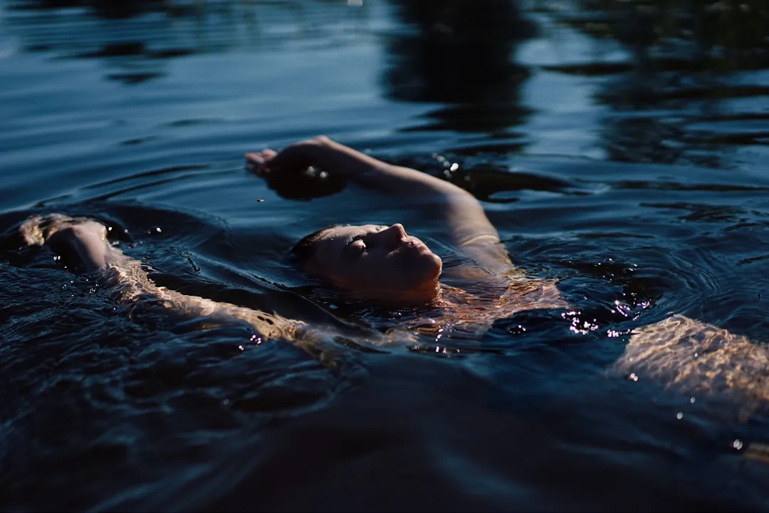 A woman laying on her back in tranquil water